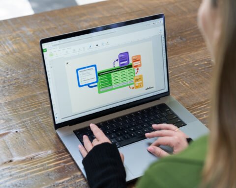 Person using a laptop displaying Workiva's ESG disclosure workflow on a wooden table.