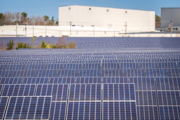 Rows of photovoltaic panels at a large solar farm generating renewable electricity.